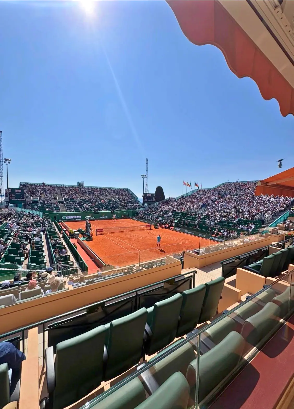 The clay centre court of the Monte-Carlo Masters seen from a box, full stands in the sun